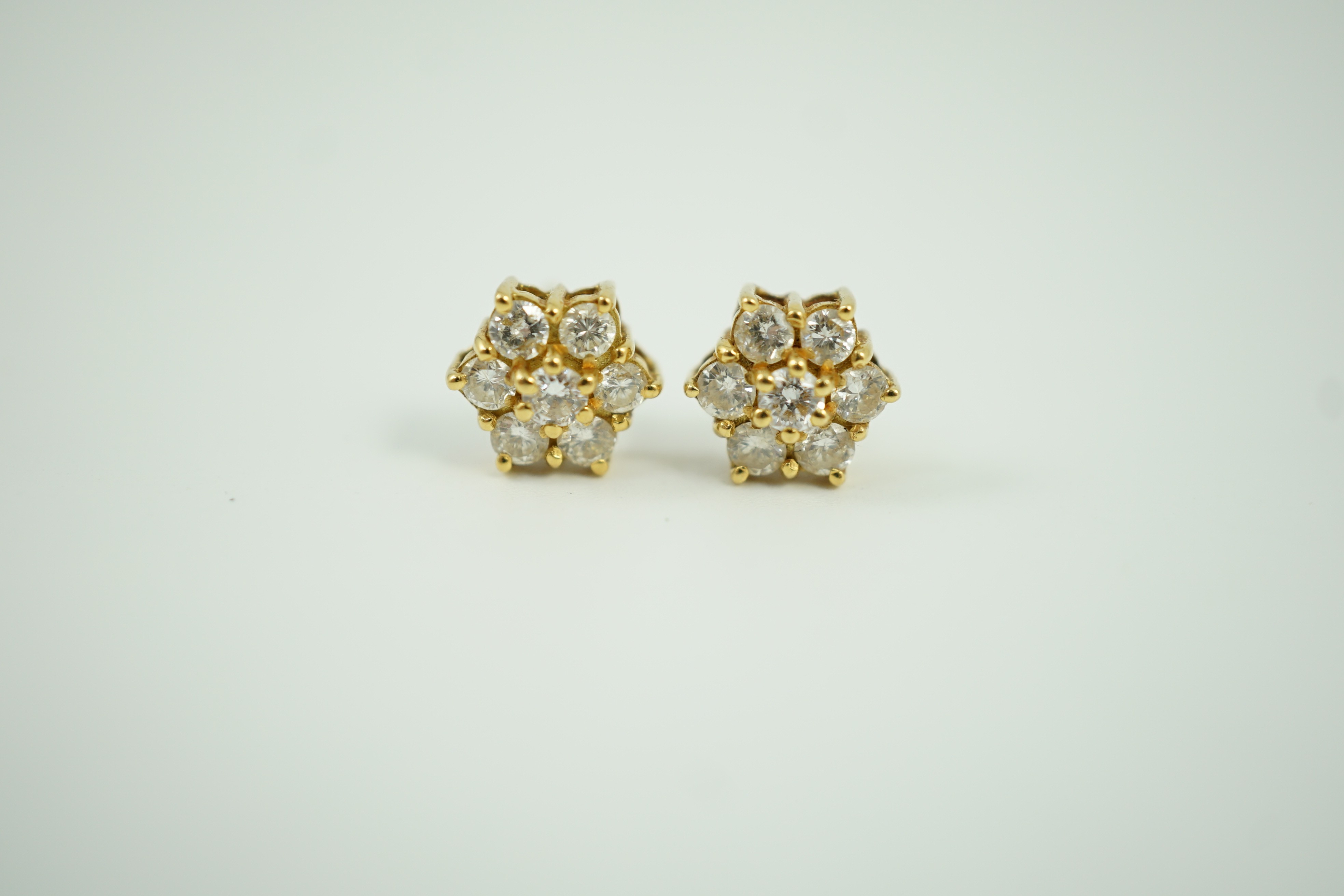 A pair of yellow metal and seven stone diamond cluster set ear studs, 7mm, gross weight 2.8 grams.